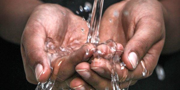 water streaming into cupped hands