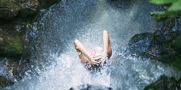 person standing in a waterfall