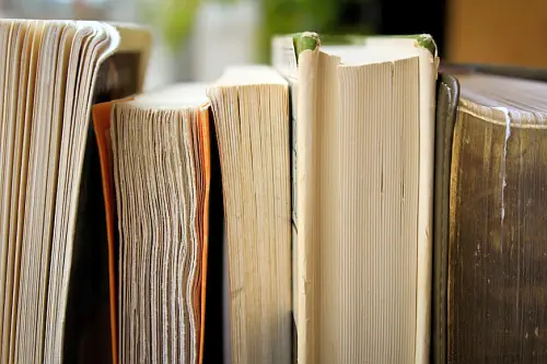 The thumbed through pages of a set of books, seen from closeby.